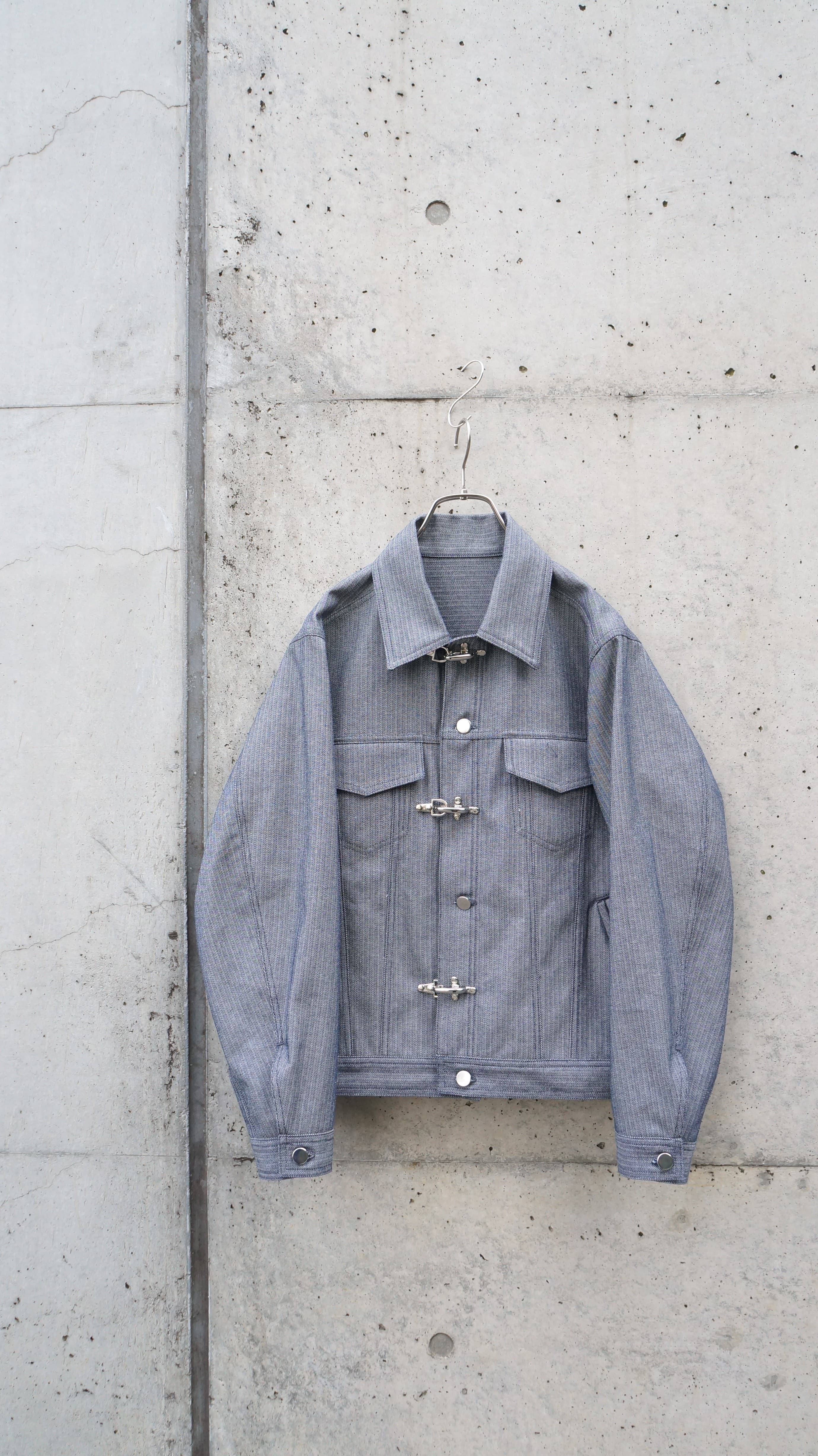 デニムのような質感のコットン生地。金属ボタンとファイヤーマンフックを使っています。