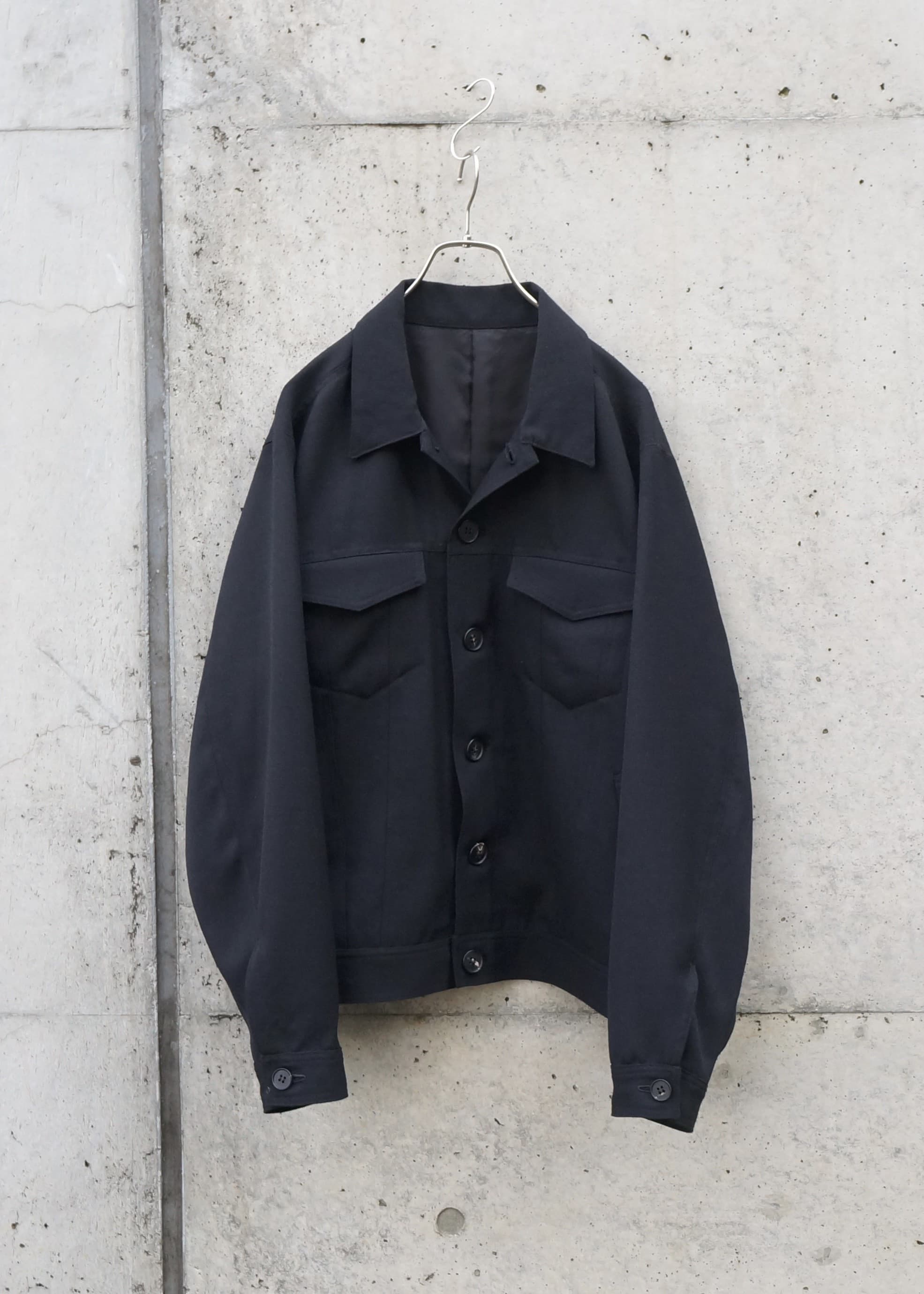 斜めの綾目模様が特徴で、滑らかな光沢としっかりとしたハリ感を持つ生地。無骨さと上品さが共存する一着。