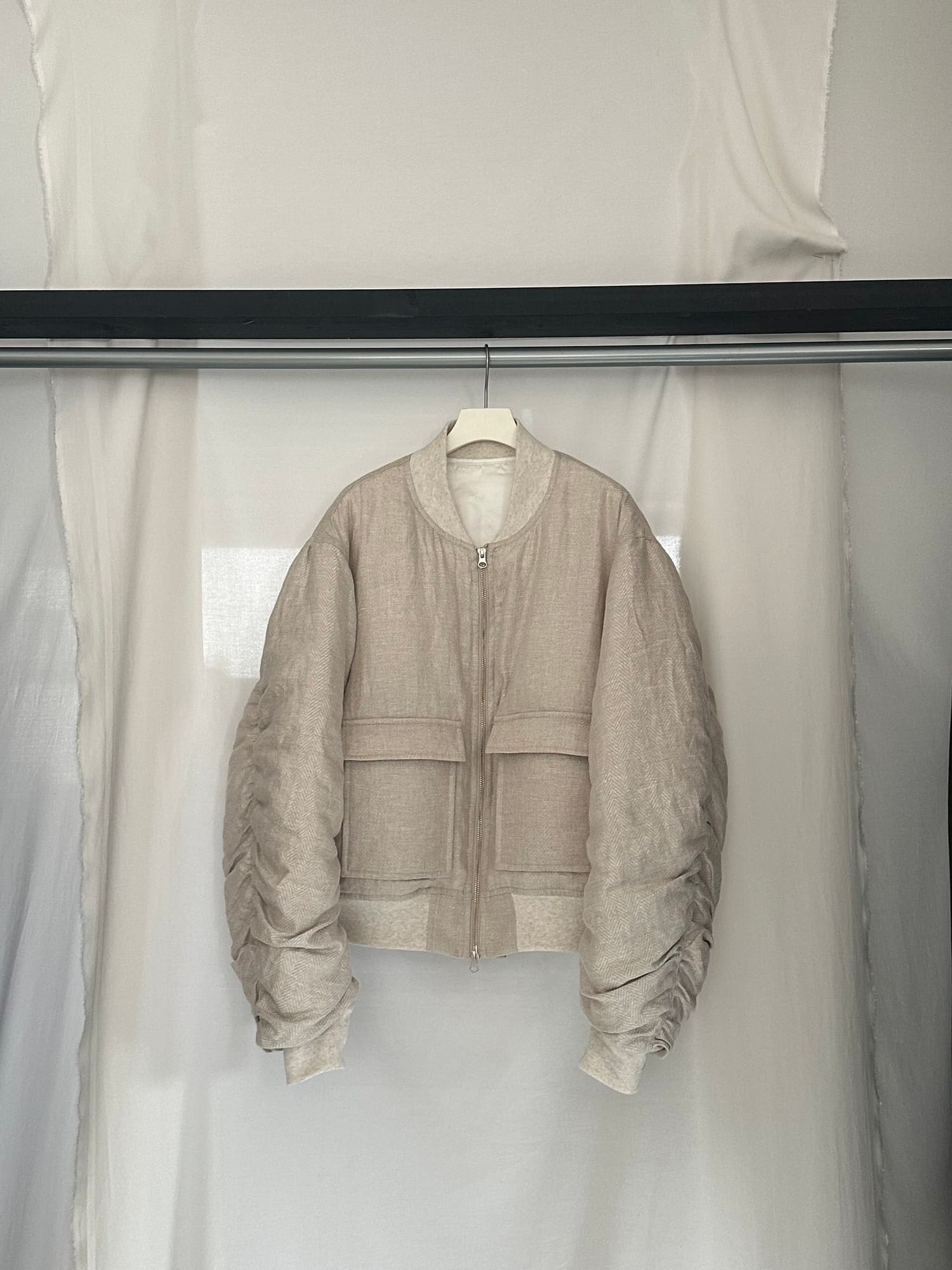 リネンの薄い生地をベースに、中綿を入れ冬に快適に着られる仕様に。スクエアの大きなポケットを採用し個性的な一着に。