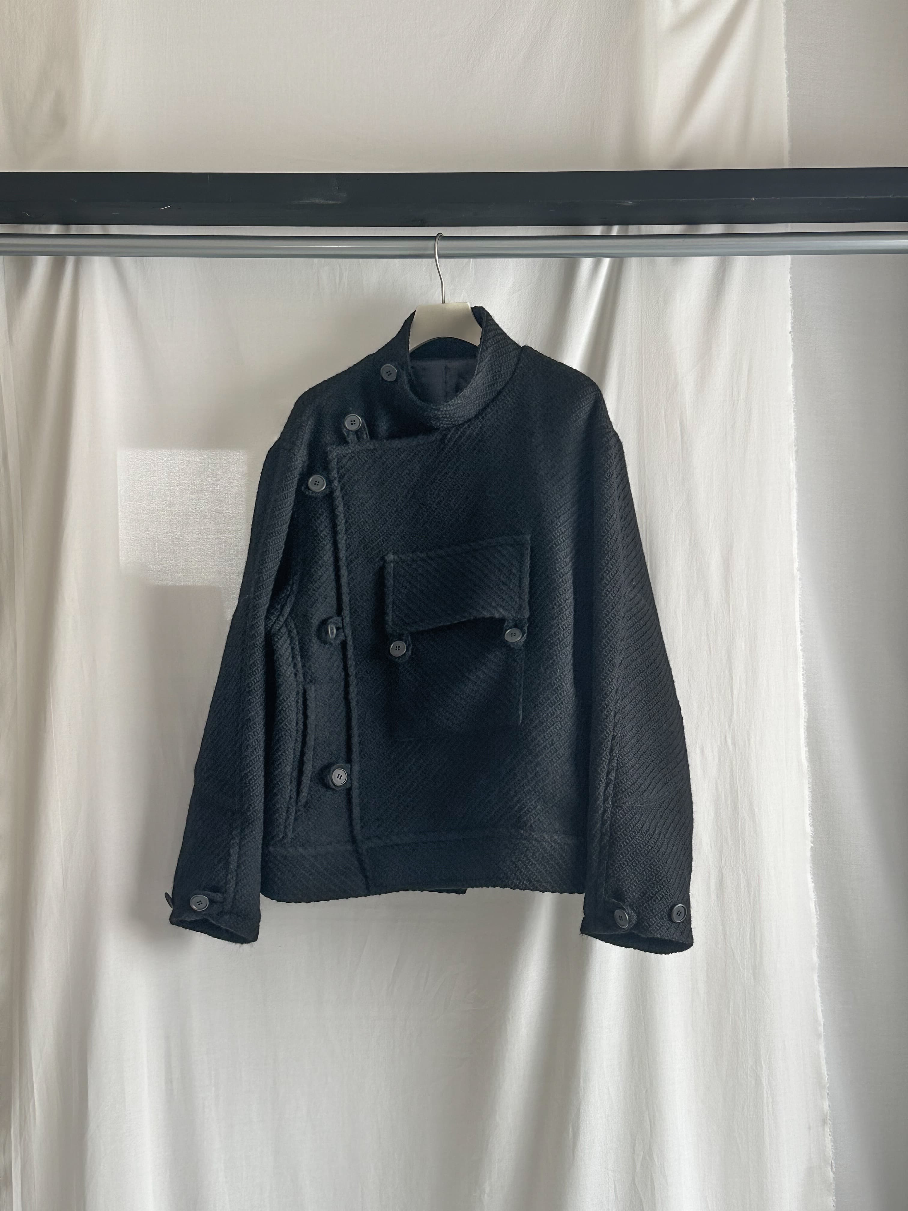 アシンメトリーな見頃に柔らかい生地を合わせた一着。左前の大きなスクエアポケットが特徴。